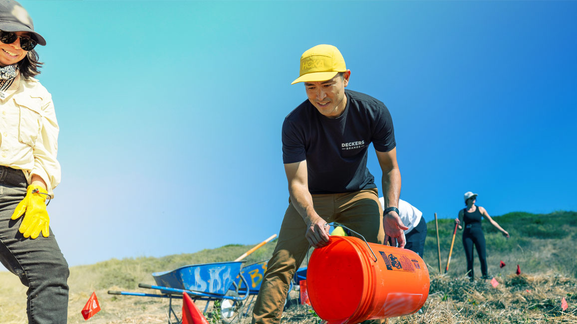 A person holding an orange bucket