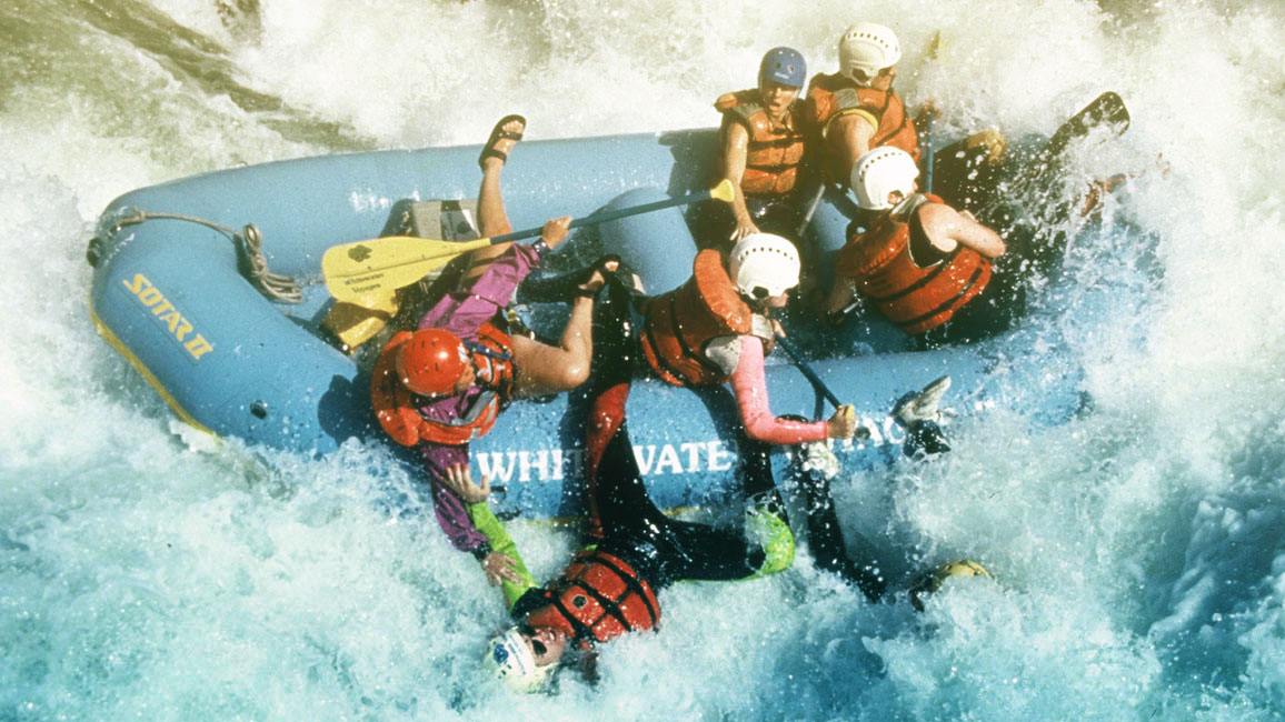 People whitewater rafting in big rapids